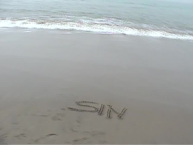 the word SIN is washed away by the tide on the beach