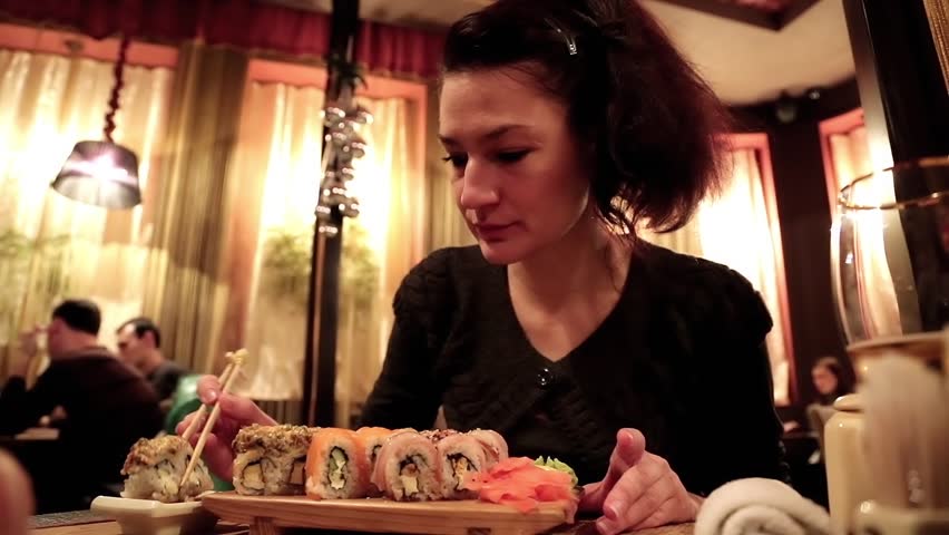 Woman eating sushi in a Japanese restaurant