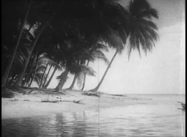 Wide shot natives arriving on island in canoes