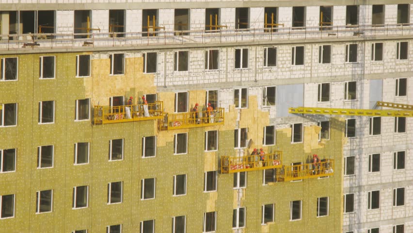 Workers making insulation on high-rise building. Timelapse