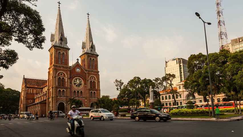 HO CHI MINH CITY, VIETNAM - JANUARY 27, 2013: Timelapse view on Notre-Dame Cathedral in Ho Chi Minh City. Traffic with unrecognizable people can be seen in the foreground.
