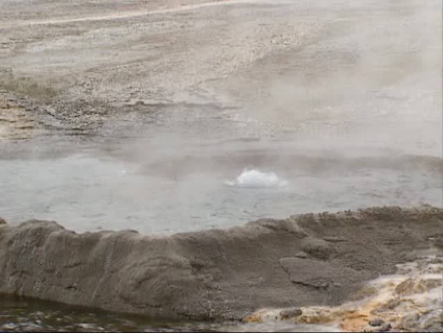 Bubbling water in Cliff geyser, Black Sand Basin, Yellowstone National Park. Cliff Geyser has a cliff-like wall formed around the crater.