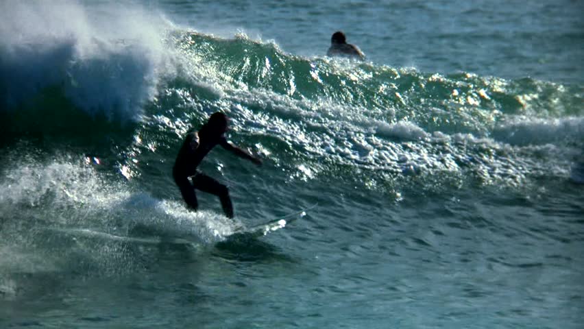 Slow-motion surfer beautifully backlit.