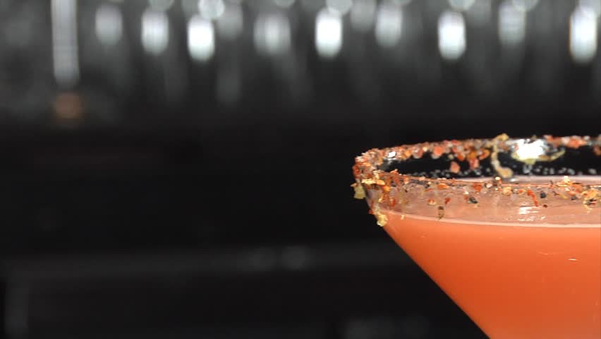 Sugar is sprinkled onto martini/ Pink Martini is flavored with sugar by a bartender