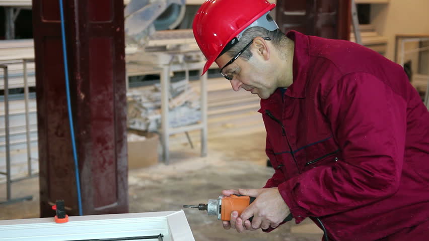 Worker Using Power Tool in Workshop.
PVC windows and doors manufacturing. HD1080p.