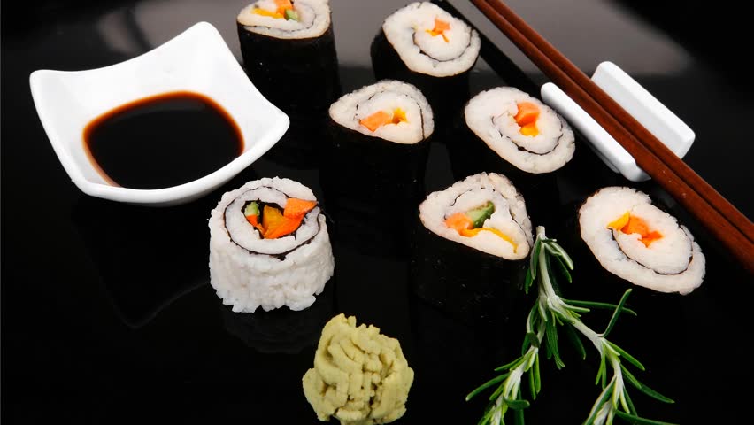 Roll with Cucumber Cream Cheese with raw Tuna and Salmon inside. on black wooden plate. Japanese traditional Cuisine