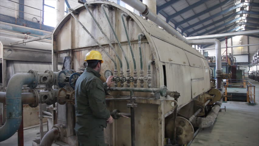 Man working in a factory, controlling of devices in the sugar factory