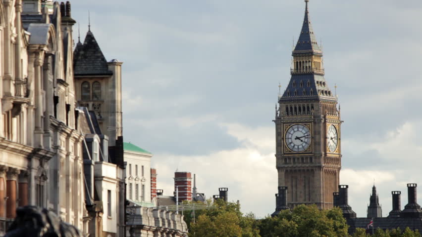 A stationary shot from Lord Nelson's monument on Trafalgar Square. The camera focuses on Big Ben clock tower which is seen in the distance. 