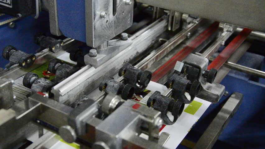 folding machine folds printed offset sheet as part of newspaper brochure in print house