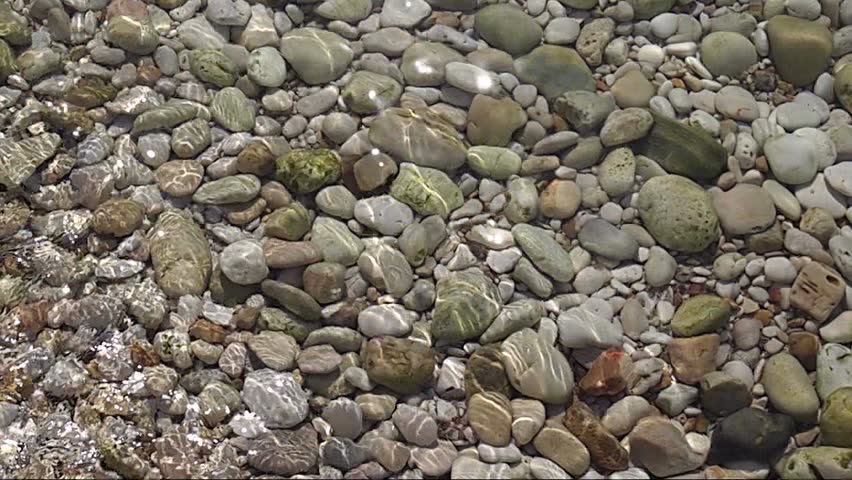 Sea cost water tides
over pebble stones
