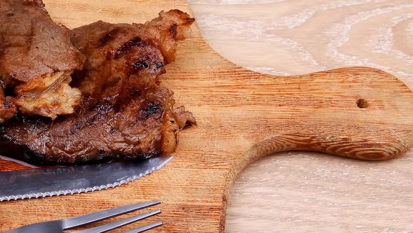 bbq beef meat fillet on wooden plate with cutlery
