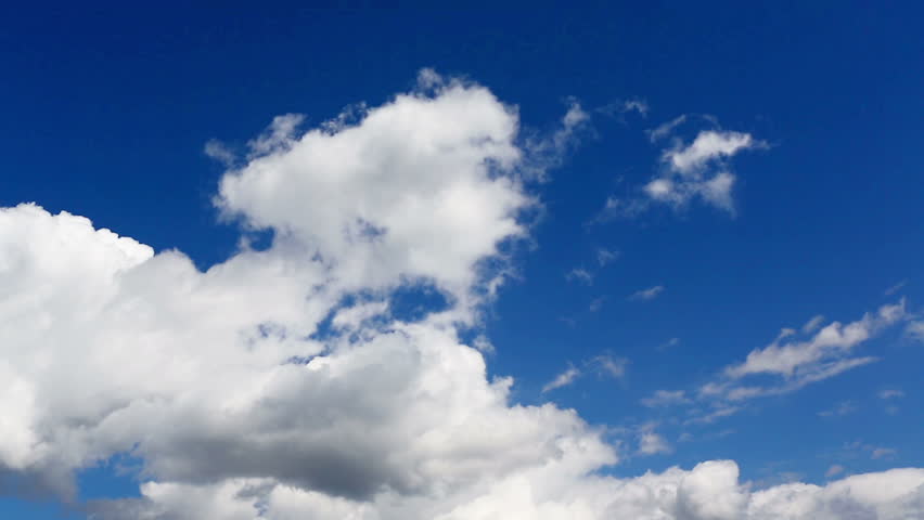 Time lapse clip of white fluffy clouds over blue sky