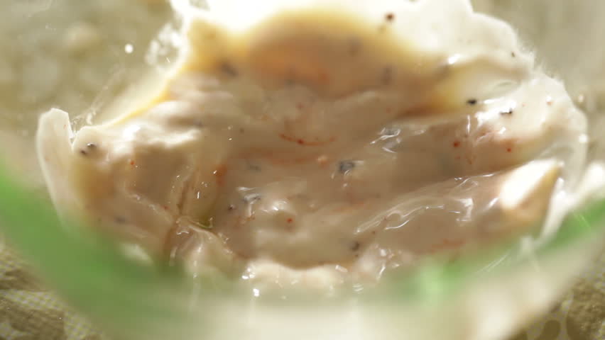 Dunking a shrimp in a white sauce.