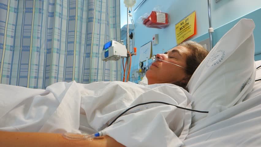 a female patient rests in a hospital bed