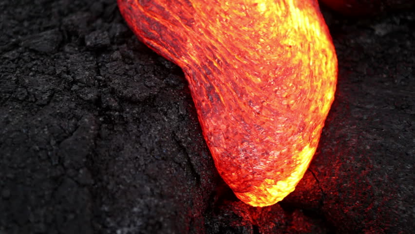 Volcanic Eruption: Closeup of molten lava flow at the ocean entry of the Kilauea volcano's Pu`u `O`o eruption in Hawaii. The magma creeps slowly forward, pulsating and cooling.
