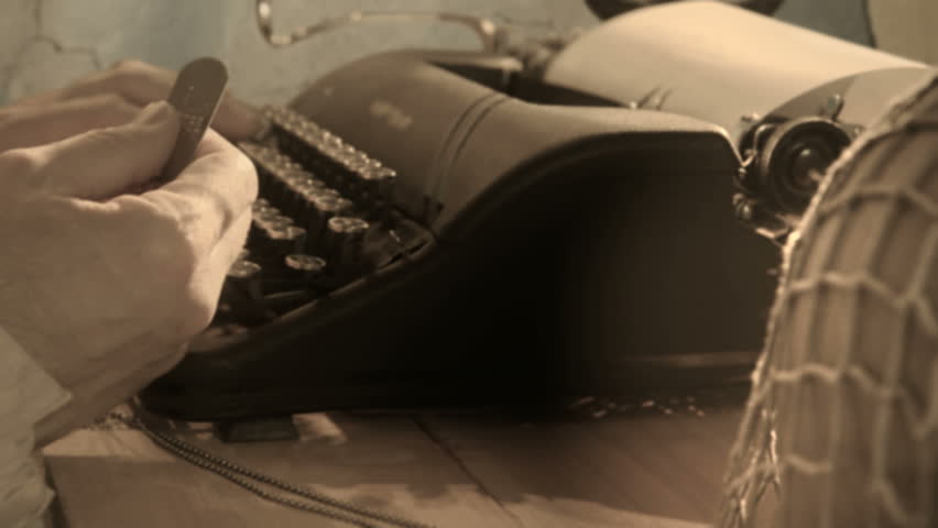 A man puts down the dog tags of a fallen soldier and starts typing a letter on a manual typewriter.