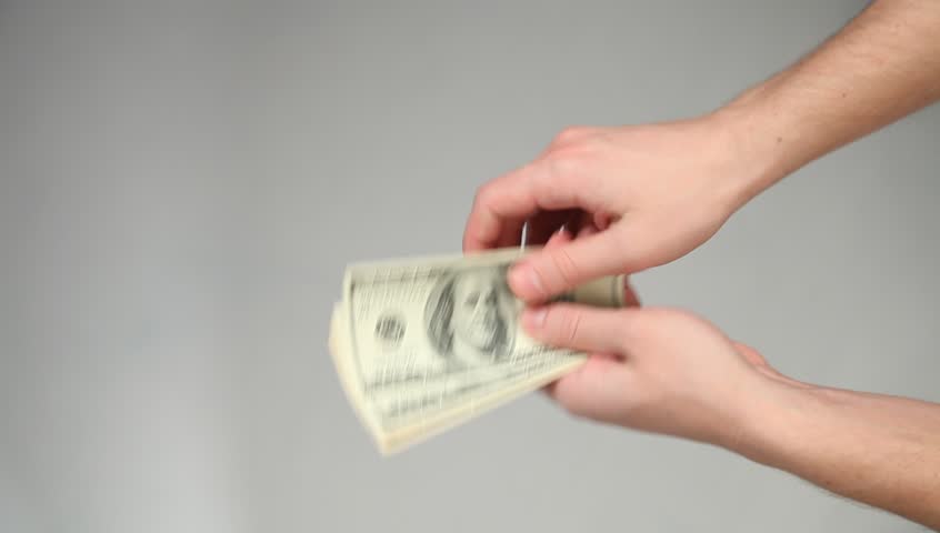 Hands giving and taking dollars on grey background