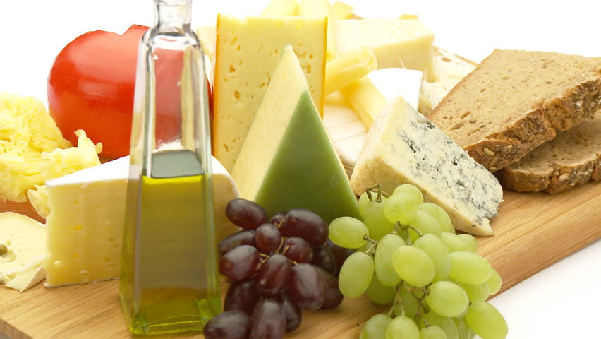 assortment of cheese with grapes, bread and olive oil
