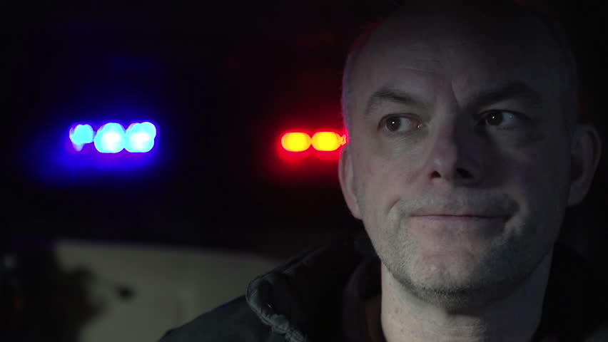 Man being pulled over by a police officer with flashing lights