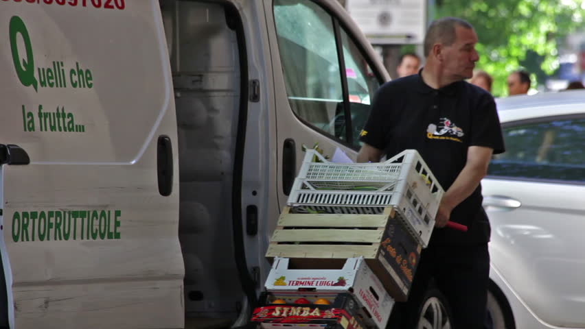 ROME - CIRCA MAY 2012 A produce-delivery man brings his wares into a building