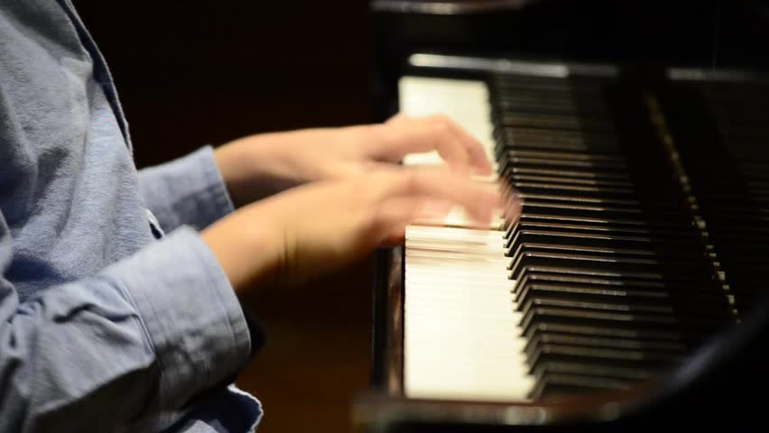 Kid playing nice song on a grand piano during recital (close up) High Definition HD 1080P