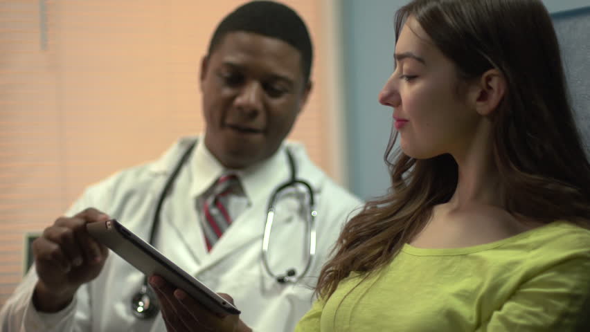 African American doctor using a tablet to explain patient's condition