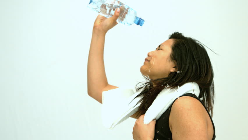 Sportive woman splashing her face in slow motion