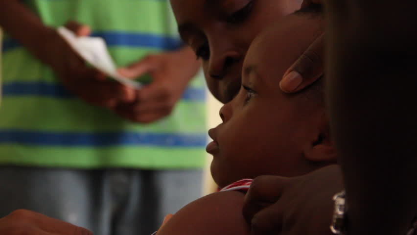 PORT AU PRINCE, HAITI  - CIRCA MAY 2012: child receives vaccine shot at a clinic