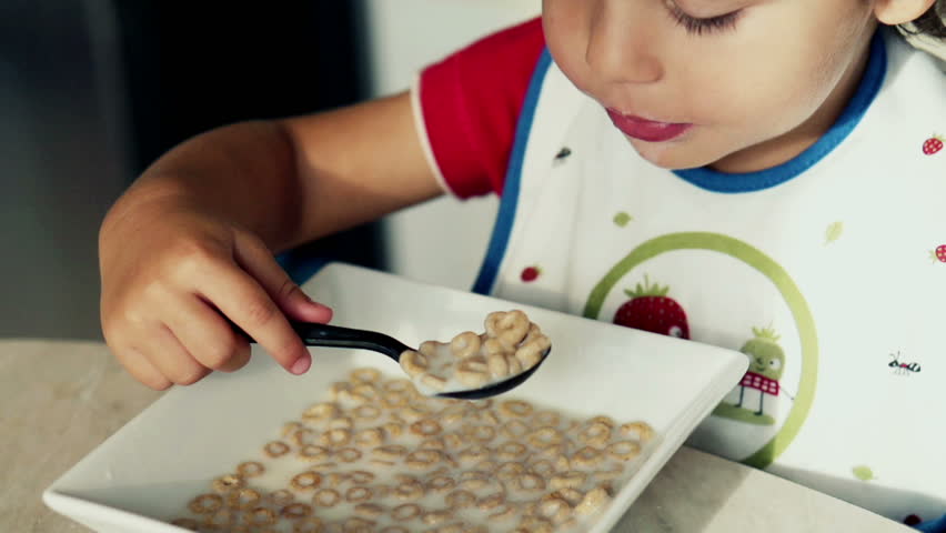 Little boy eating cornflakes with milk, slow motion shot at 120fps
