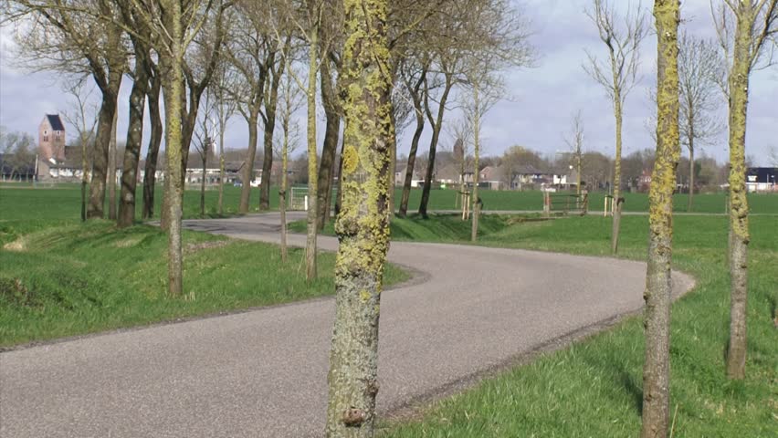 Winding road in Dutch polder landscape at Niehove, province of Groningen.