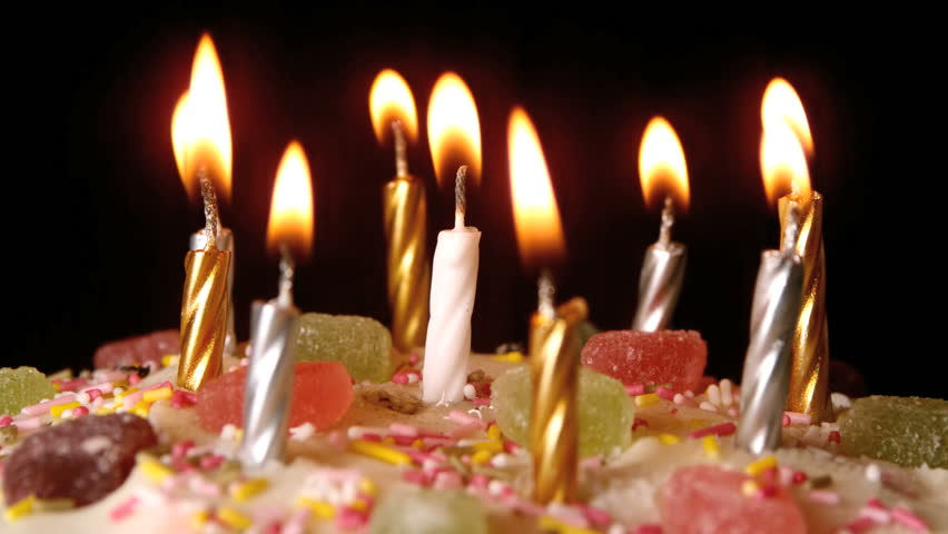 Birthday candles being blown out on a delicious cake close up in slow motion