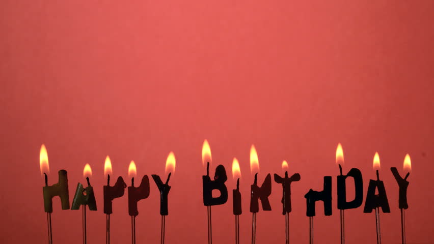 Silhouette of happy birthday candles being extinguished in slow motion