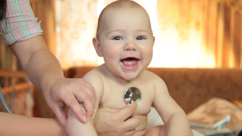 Primary care pediatrician examining happy baby with  stethoscope