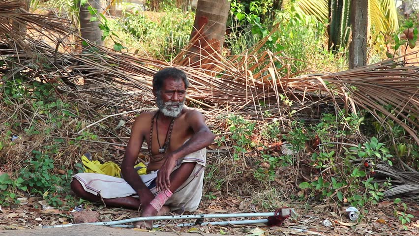 CALANGUTE, INDIA - MARCH 11, 2013: Homeless man sitting on the ground and waiting for alms from passers-by. on March 11, 2013 in Calangute, India