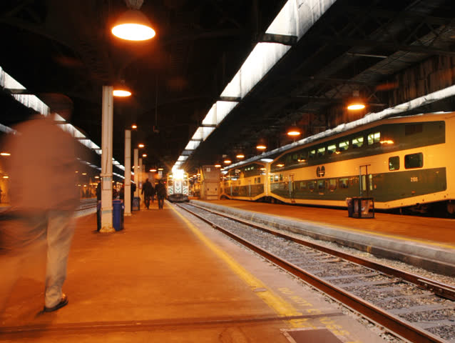 Time lapse. Busy train platform and commuters. (With left-to-right pan)