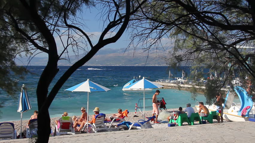 People on the beach, sunbathe and enjoy on vacation. Summertime at Adriatic Sea on the island Brac in Croatia
