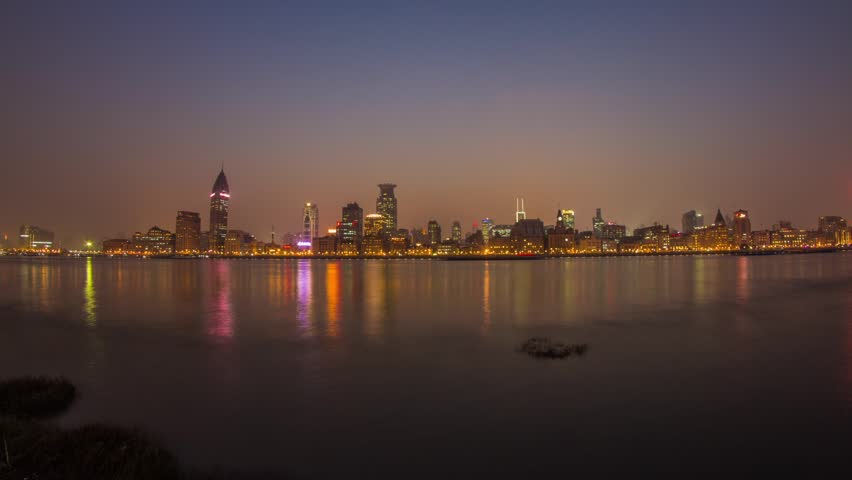 SHANGHAI - CIRCA 2013: Time Lapse Day to Night Time Lapse in Shanghai, China. Busy Boat Traffic on the River and getting lower tide as it gets darker the night. Photo Sequence from DSLR Camera