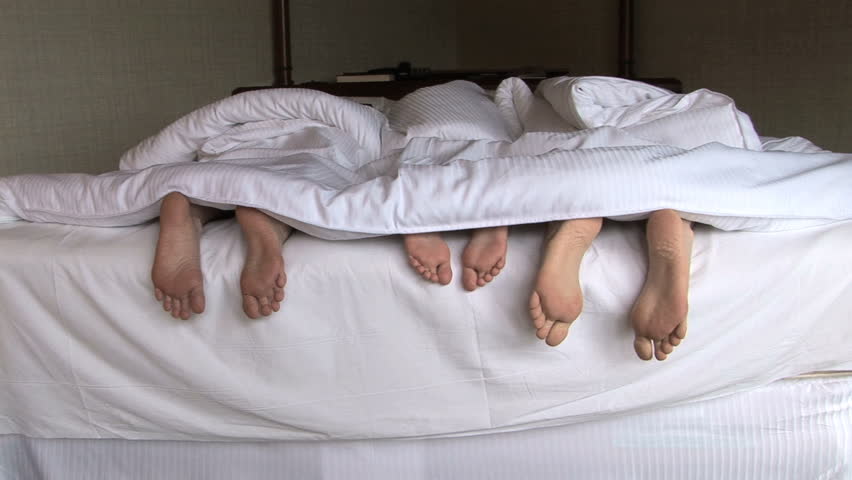 Feet of family snuggling in bed, Seattle, Washington