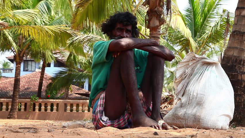 CALANGUTE, INDIA - MARCH 11, 2013: Homeless man sitting on the ground and waiting for alms from passers-by on March 11, 2013 in Calangute, India