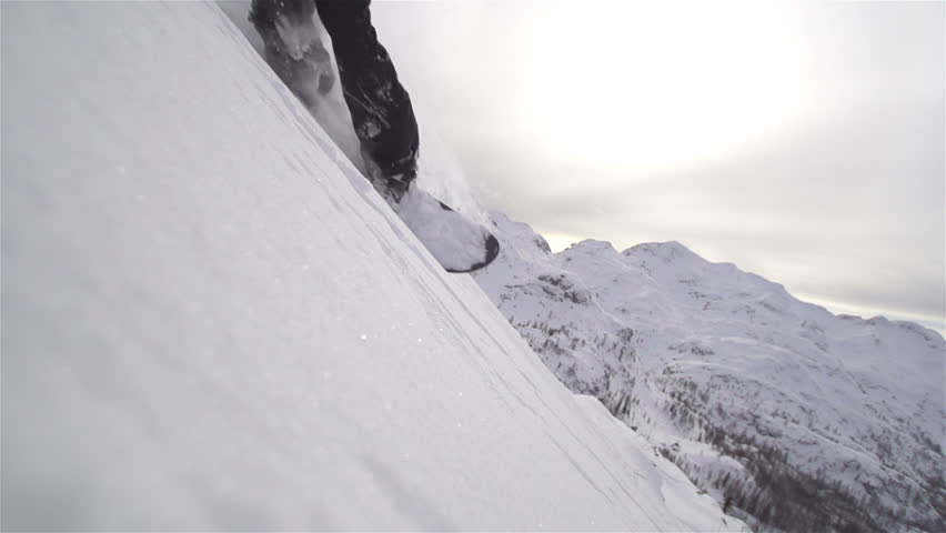 SLOW MOTION: snowboarder carving in powder