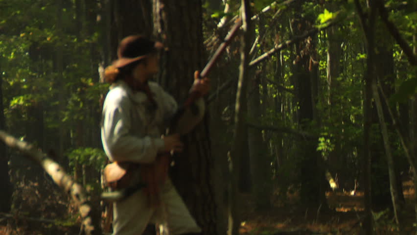 VIRGINIA - OCTOBER 2009 - large-scale, epic American Revolutionary War anniversary reenactment -- in the middle of battle.  Continental Army Minuteman / Militia in the woods, loads and fires.
