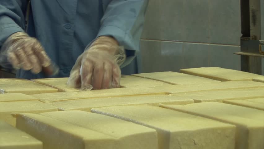 Plant for the production of cheese. Work corrects cheese on the table