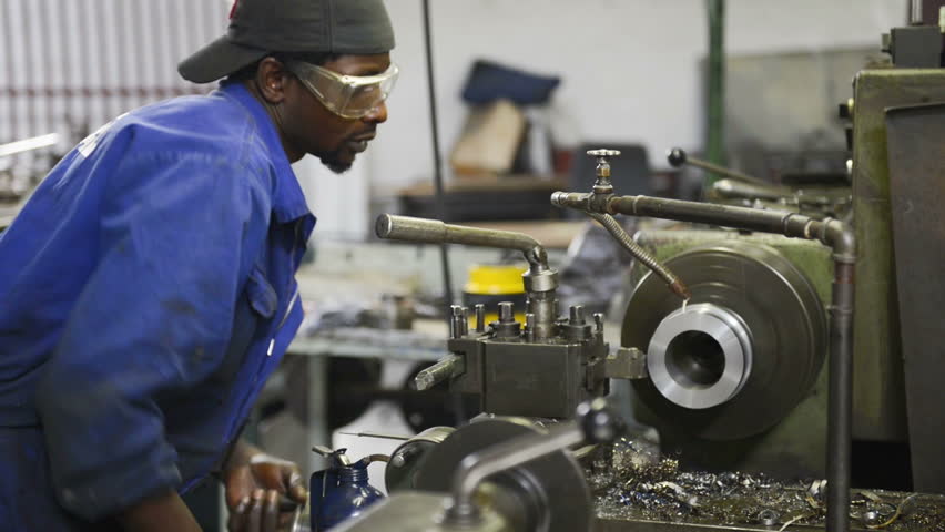 An industrial service repairmen labouring in workshop, selective focus, working on industry machine 