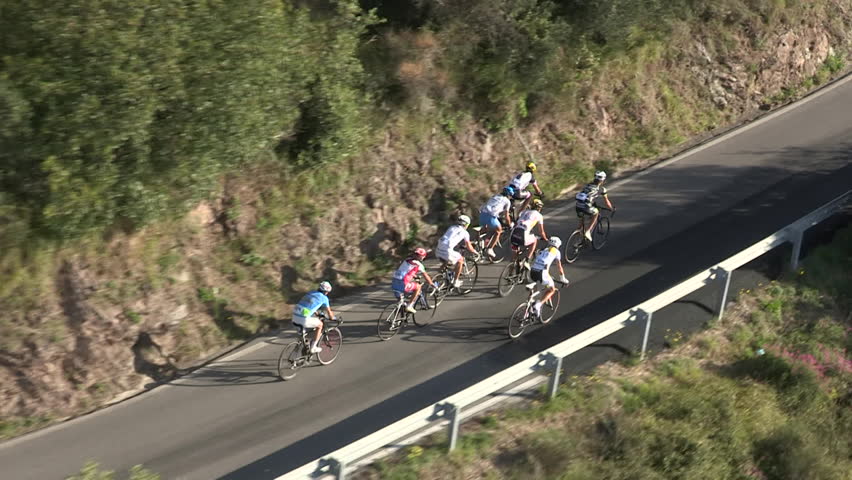 MONEGLIA, ITALY â SEPTEMBER 11 2011: Small pack of cyclists pushing steadily up a hill on September 11 2011 in Moneglia

