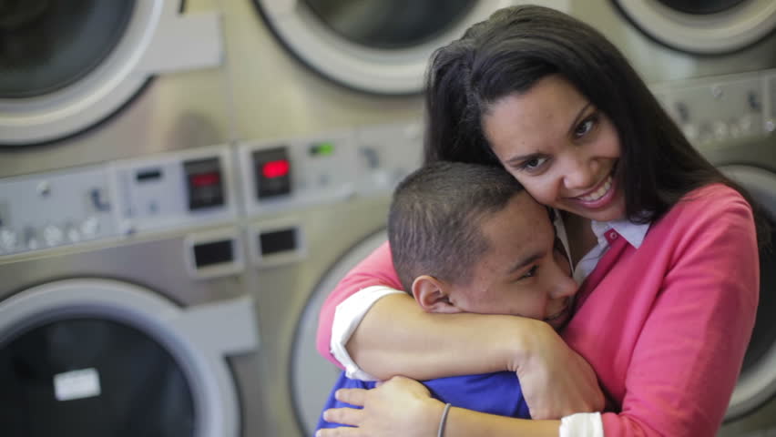 Working mom smiling hugging and embracing her kid 