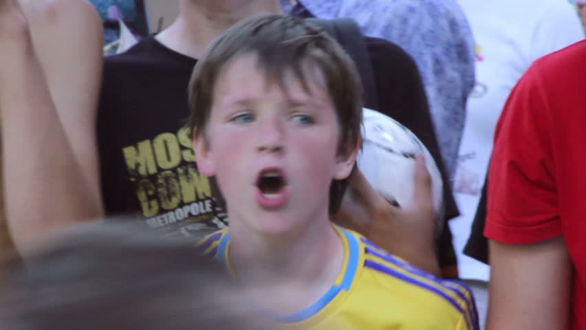 KIEV, UKRAINE - JUNE 13: Young boy, football fan, shouts after soccer match asking for autograph during the Euro 2012 tournament. He shouts "Sheva" - name of Andrey Shevchenko football star.