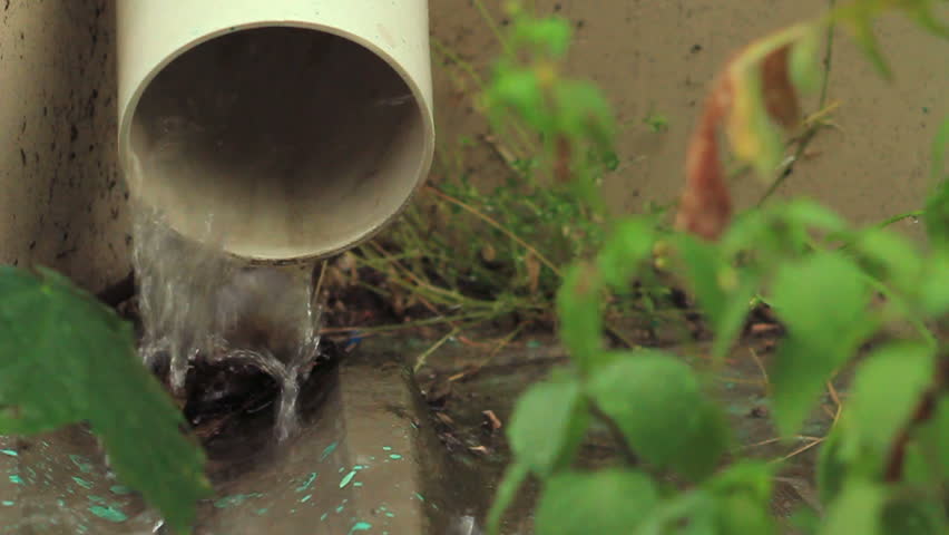 Rainwater is flowing from the pipe on the ground