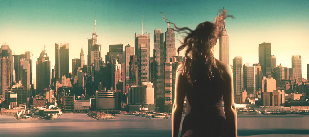 woman overlooks Manhattan blowing up, engulfed in flames, smoke.