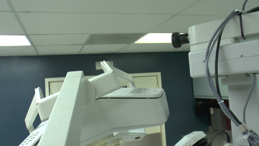 Medical assistant switches on, lowers, surgical lights, arranges equipment in operating room in preparation for next procedure. 1080p