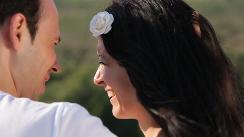Close up view of newlyweds enjoying time together,groom is running his hand through bride\x92s hair.